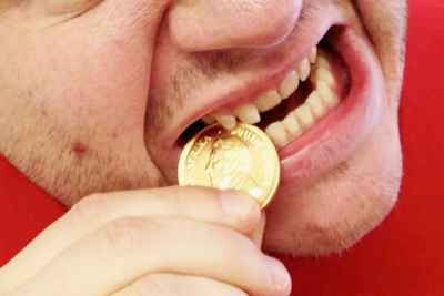 man-biting-coin-to-verify-its-authenticity-20660129.jpg