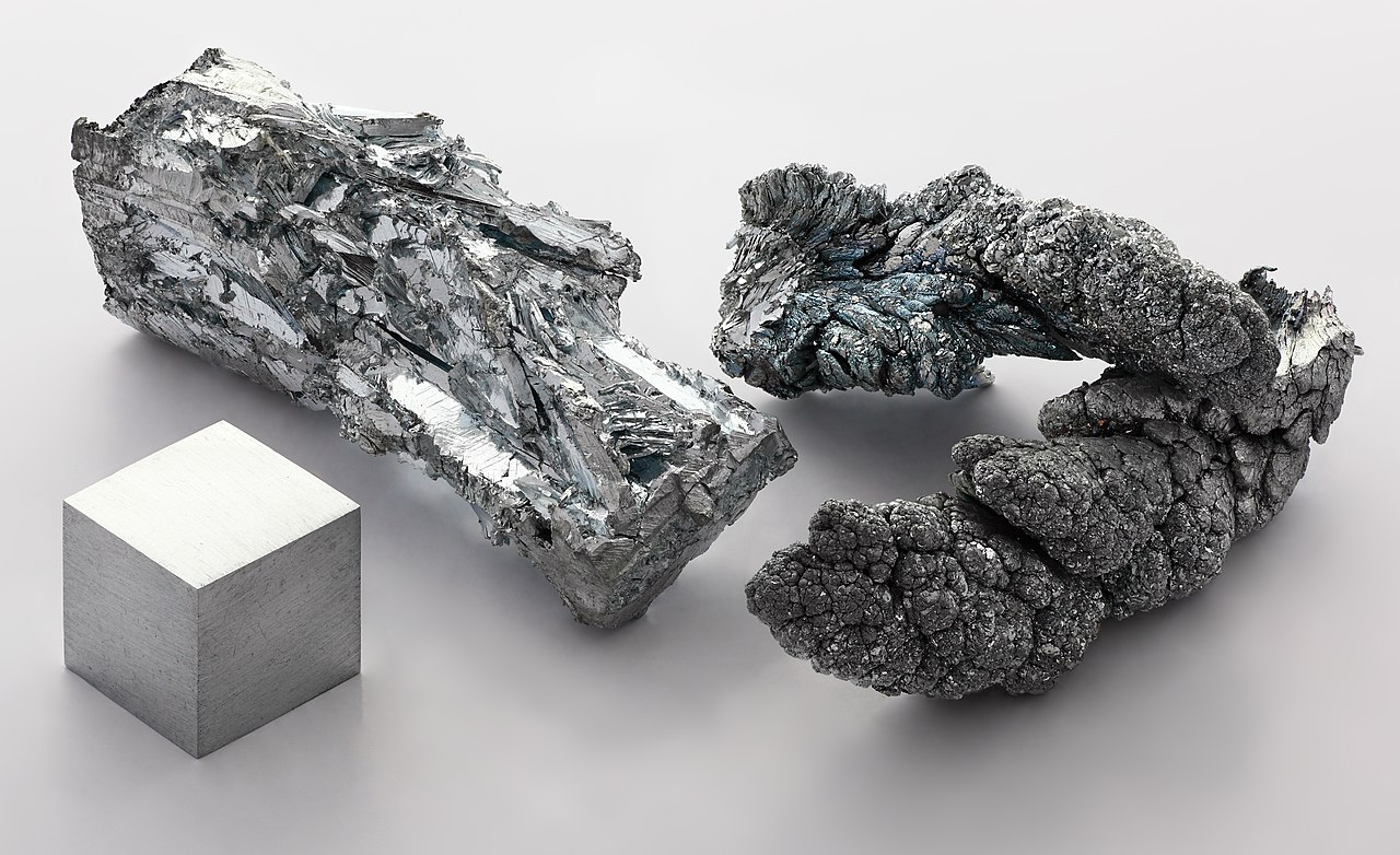 Zinc_fragment_sublimed_and_1cm3_cube.jpg