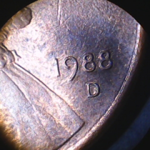 Beneath 3rd digit in date.